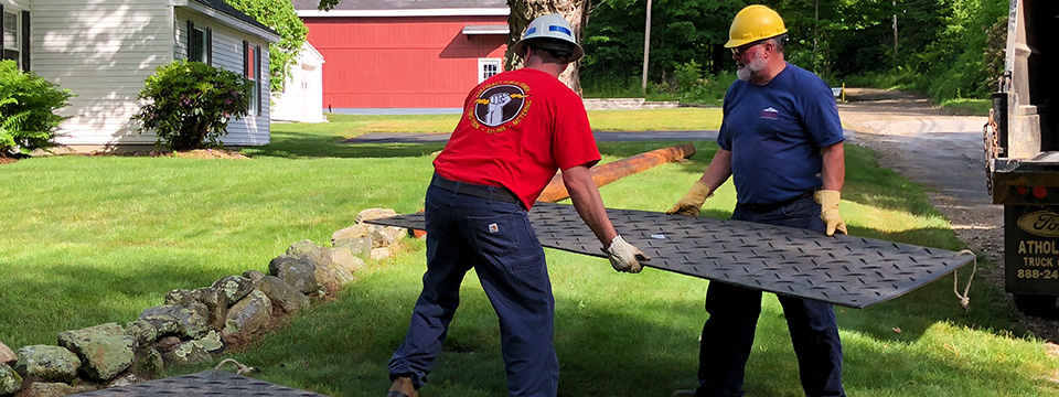 photo of AMLP linemen placing a steel plate over a trench